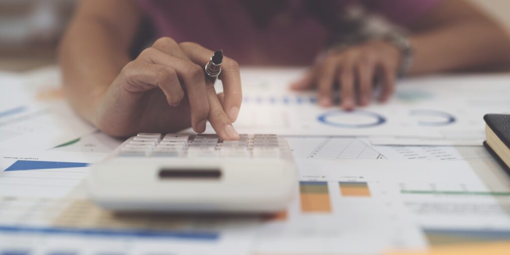 Business woman hand using calculator to calculate the company's financial results and budget